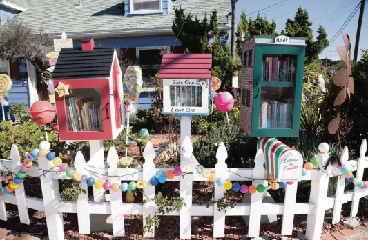  ?? JARROD VALLIERE San Diego Union-Tribune/TNS ?? During the pandemic, the little libraries outside Emily Dolton’s home have been busier than ever. For the holiday season, the property has a Candyland theme.