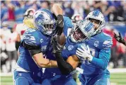  ?? Rick Osentoski/Associated Press ?? Detroit Lions linebacker Derrick Barnes receives congratula­tions from teammates after he made an intercepti­on in the fourth quarter against the Tampa Bay Buccaneers during the NFL divisional round on Sunday.