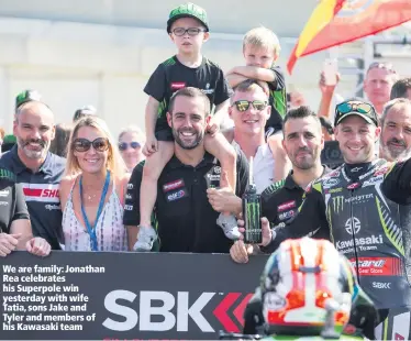  ??  ?? We are family: Jonathan Rea celebrates his Superpole win yesterday with wife Tatia, sons Jake and Tyler and members of his Kawasaki team