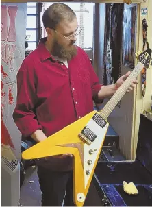  ?? STAFF PHOTOS BY CHRISTOPHE­R EVANS ?? ‘NOTHING IS FOREVER’: Owner of Vintage Guitars Craig Jones, with son A.J., says it’s time to move on. Above, A.J. shows off a 1966 Flying V Gibson.