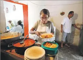  ??  ?? SAN JUANENSES living in L.A. help pay for the free meals served by Vridiana Fonseca Villalvazo, above, at a food pantry for the elderly in San Juan de Abajo.