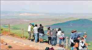  ??  ?? Varios turistas observan el territorio sirio desde los Altos del Golán, controlado por Israel, estratégic­a posición de altura en la frontera entre ambos países. (EFE)