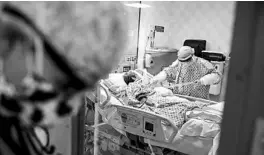  ?? JOHN MINCHILLO/AP ?? Resident physician Leslie Bottrell stands outside a room in the intensive care unit at a Yonkers, New York, hospital as a nurse suctions the lungs of a patient with COVID-19.