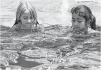  ??  ?? Robyn, left, and Alina tread water in their mermaid costumes Saturday. The girls came to the Pearland pool for their friend Ngozi Nduagu’s mermaid-themed party to celebrate her eighth birthday and her mother’s mermaid business launch.