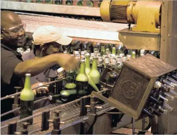  ?? PHOTO: BLOOMBERG ?? SAB employees work on the beer production line. SABMiller’s chairman, Jan du Plessis, expressed regret of looming job losses as a result of the merger.