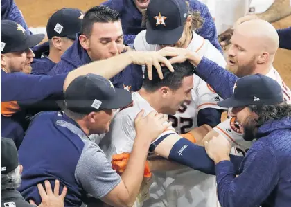  ?? Picture / AP ?? The Astros’ Alex Bregman is mobbed by teammates after hitting in the game-winning run in Game 5 in Houston. The Astros won an epic match 13-12 to take a 3-2 lead in the series.