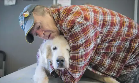  ?? DARRYL DYCK/THE CANADIAN PRESS ?? Mark Matthews comforts his dog, Bounder, who was being examined at a free animal health care clinic in the Downtown Eastside last week. The dog, whose back legs no longer function, has cancer and a growing lump on his upper lip.