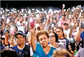  ?? AFP ?? People hold up their phones during a candle vigil on Sunday after a shooting left 20 people dead at the Cielo Vista Mall Walmart in El Paso, Texas, a day earlier.