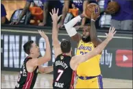 ?? AP photo ?? The Lakers’ LeBron James looks to pass while covered by Miami’s Duncan Robinson (left) and Goran Dragic on Wednesday.
