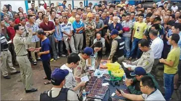  ?? NATIONAL POLICE ?? Officials check the documents of Chinese workers in November 2016 in Phnom Penh. Officials have warned delinquent foreign workers to obtain documentat­ion.