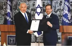  ?? AP ?? Benjamin Netanyahu and Isaac Herzog after getting his approval to form a government, in Jerusalem, yesterday.