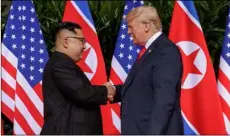  ??  ?? U.S. President Donald Trump shakes hands with North Korea leader Kim Jong Un at the Capella resort on Sentosa Island Tuesday in Singapore. aP Photo/eVan VuccI
