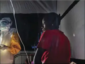  ??  ?? In this July 13 photo, health workers dressed in protective gear check on Ivette Adania, 24, a mother of four whose husband died of Ebola, at a treatment center in Beni, Congo. AP PHOTO/ JEROME DELAY