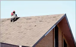  ?? NEWS PHOTO COLLIN GALLANT ?? Workers inspect wind damage to the roof of the First Assembly of God church on the Southeast Hill in Medicine Hat on Thursday morning.