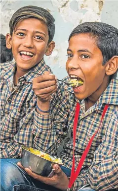  ??  ?? Mohsin and a classmate enjoy one of Mary’s meals.