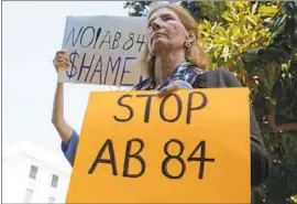  ?? Rich Pedroncell­i Associated Press ?? MARY BELSHE and other open-government activists protest AB 84 on Tuesday in Sacramento. The measure’s author said it was “an anti-dark-money bill.”