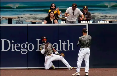  ?? (AP PHOTO/GREGORY BULL) ?? San Diego Padres left fielder Jurickson Profar, below right, reacts with teammate center fielder Trent Grisham after making a catch at the wall for the out on San Francisco Giants’ Mike Tauchman during the first inning of a baseball game on Sunday in San Diego.