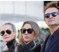  ?? FOTO: VALAT/AFP ?? Hallydays dritte Ehefrau Laeticia (links) ist Alleinerbi­n. Seine Kinder Laura (Mitte) und David aus früheren Beziehunge­n enterbte der Musiker.