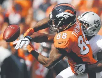  ?? Joe Amon, The Denver Post ?? The Raiders’ T.J. Carrie breaks up a pass intended for the Broncos’ Demaryius Thomas during the first quarter Sunday.