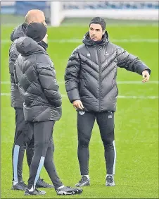  ?? — AFP photo ?? File photo shows Arteta (right) talks with Guardiola (centre) during a team training session at City Football Academy in Manchester, north west England.
