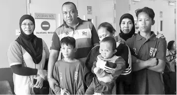  ??  ?? Abe (back row second left) handing the assistance to the victims at the Sarawak General Hospital yesterday.