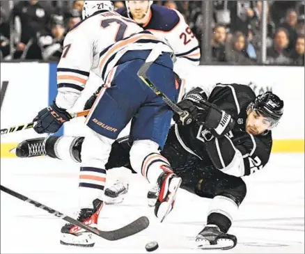  ?? Photograph­s by Wally Skalij Los Angeles Times ?? ANDREAS ATHANASIOU (22) collides with the Oilers’ Brett Kulak. The Kings erased a 2-0 deficit but stumbled late at home.
