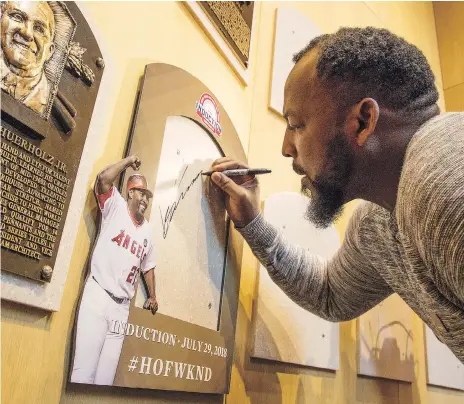  ??  ?? Vladimir Guerrero uses a visit to Cooperstow­n’s Baseball Hall of Fame this week to sign the spot where his plaque will hang. Guerrero played 16 seasons in the majors, eight of those with the Montreal Expos. MILO STEWART JR./NATIONAL BASEBALL HALL OF...