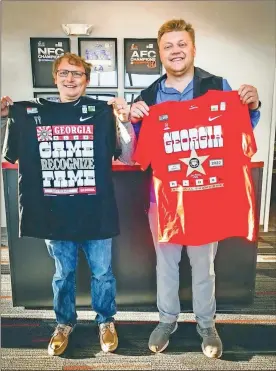  ?? Contribute­d ?? The Cedarstrea­m Company’s Jesse Cook (left) and Hunter Ward pose with the two shirts printed by the Cedartown business celebratin­g UGA’s national championsh­ip.