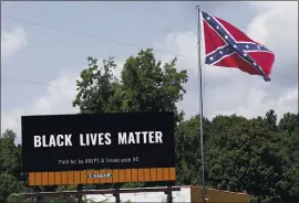  ?? GERRY BROOME — THE ASSOCIATED PRESS ?? A Black Lives Matter billboard is seen next to a Confederat­e flag in Pittsboro, N.C., on Thursday. The Pentagon has banned the flag on military installati­ons.