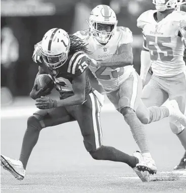  ?? JEFF HAYNES/AP ?? Dolphins cornerback Xavien Howard (25) attempts to bring down Colts receiver T.Y. Hilton (13) after a catch during Sunday’s game in Indianapol­is. The Colts won 27-24 as the Dolphins gave up 13 points in the fourth quarter.