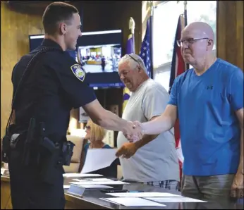  ?? Staff photo/Skyler Mitchell ?? Officer Lance Brunswick shakes Councilor Dan Uhlenhake’s hand after he was sworn in by St. Marys Mayor Patrick McGowan Monday night at the city council meeting.
