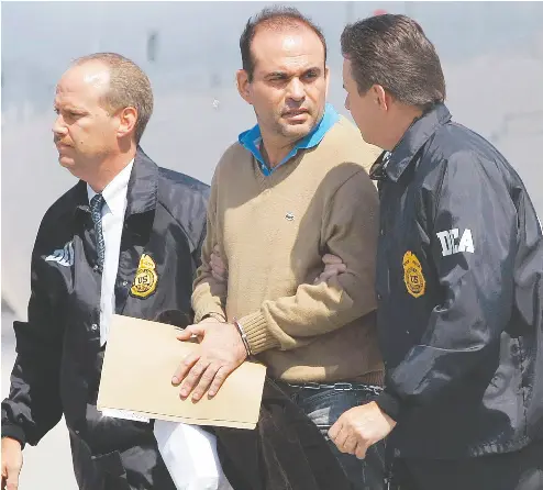  ?? AP PHOTO / ALAN DIAZ ?? In this May 2008 photo, Colombian paramilita­ry warlord Salvatore Mancuso, centre, is escorted by U. S. DEA Agents at his arrival in the Miami-area city of Opa-locka, Fla.