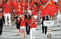  ?? ZHENG HUANSONG / XINHUA ?? China’s flag bearers Zhu Ting (left) and Zhao Shuai lead their delegation as they parade during the opening ceremony of the Tokyo 2020 Olympic Games on Friday.