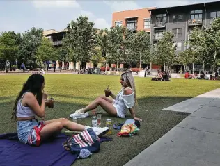  ?? Kin Man Hui / Staff photograph­er ?? Monet Martinez , left, and Andrea Sanchez sip cocktails on the lawn at the Pearl on Friday. San Antonio officials are monitoring a number of statistics as the city reopens amid the pandemic.