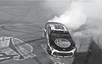  ?? MEG OLIPHANT/GETTY IMAGES ?? Christophe­r Bell, driver of the No. 20 Toyota, celebrates with a burnout after winning the NASCAR Cup Series Shriners Children's 500 at Phoenix Raceway on Sunday.