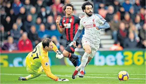  ??  ?? At the third stroke: Liverpool’s Mohamed Salah rounds Bournemout­h keeper Asmir Begovic to seal his hat-trick at the Vitality Stadium yesterday