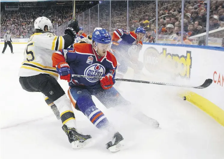  ?? JASON FRANSON/THE CANADIAN PRESS ?? The Boston Bruins’ Brandon Carlo and the Oilers’ Oscar Klefbom battle for the puck Thursday during the Oilers’ 7-4 victory at Rogers Place.