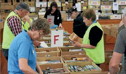  ?? KATRINA TANIRAU ?? Te Aroha Mountain Lions volunteers sort through boxes at their annual Book Fair.