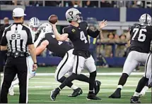  ?? RON JENKINS / AP ?? Referee Shawn Hochuli (83) looks on as Las Vegas Raiders quarterbac­k Derek Carr (4) throws a pass against the Dallas Cowboys in Arlington, Texas, Thursday.