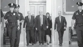  ?? ZACH GIBSON/GETTY IMAGES ?? President-elect Donald Trump, center, walks with Senate Majority Leader Mitch McConnell and his wife, Melania Trump, before a meeting at the U.S. Capitol on Thursday.