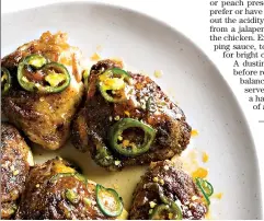  ??  ?? This image released by Milk Street shows a recipe for glazed chicken thighs, seasoned with jalapenos and apricot preserves. A dusting of earthy cumin on the chicken before roasting helps ground the flavors and balance the brighter sweetness of the preserves. (Milk Street via AP)