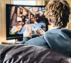  ?? HESHPHOTO / GETTY ?? Un joven jugando con un videojuego frente al televisor