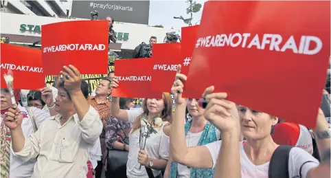  ?? AP ?? Activists hold up placards condemning Thursday’s attack during a rally yesterday outside the Starbucks cafe where terrorists struck in Jakarta, Indonesia. Residents were shaken but refused to be cowed a day after the deadly attacks in a busy district...