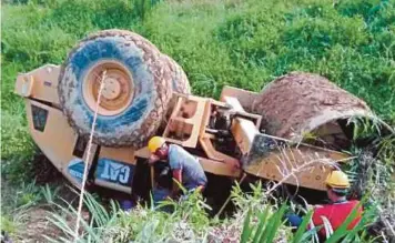  ??  ?? PEKERJA ladang berusaha mengeluark­an mangsa dihempap jentera pengolek dipandunya dalam kejadian di kawasan sebuah ladang sawit di Jalan Miri-Bintulu.