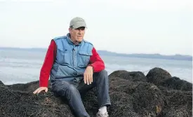  ??  ?? Kenneth Ross of Pembroke, Me., sits on rockweed at low tide. He has sued a Canadian company for harvesting the weed.