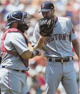  ?? AP PHOTOS ?? SLOW START: Starter Chris Sale talks with catcher Sandy Leon in the first inning of the Sox’ win in Baltimore yesterday. Sale didn’t get any help from third baseman Pablo Sandoval (below), who failed to tag Joey Rickard on a stolen base attempt.