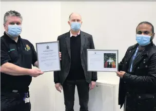  ??  ?? ● First Responder Andrew Walmsley presents the Certificat­e of Recognitio­n to Drs Abdul Mannan and John O’Malley