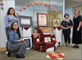  ??  ?? KOFA HIGH SCHOOL ART CLUB MEMBERS created a Day of the Dead altar for display at the Yuma Main Library. From left are Patricia Alvares (kneeling), Marilyn Garcia and Arlete Franco, with their teacher, Amy Seeley.