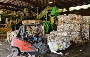  ?? SEAN D. ELLIOT/THE DAY ?? A worker at Willimanti­c Waste Paper Co. moves bales of recycled materials Thursday from the baling machine to the loading dock.