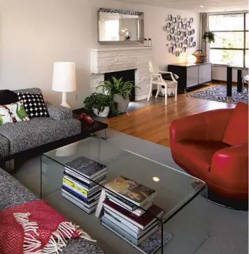  ?? MIKE SEIGEL/THE SEATTLE TIMES PHOTOS ?? Red accents pop up in the living area of Stina and Aaron Brown’s Magnolia home: in the chair, the throw, the retro phone and a tactile painting with special meaning.